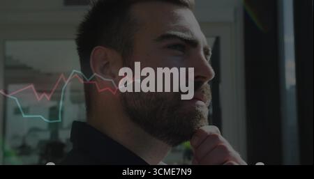 Homme contemplant portant un blazer près de la fenêtre du bureau, avec des superpositions de graphiques de lignes rouges et bleues Banque D'Images