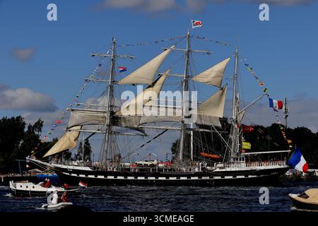 La barque française Belem affiche des banderoles et des voiles crème tout en passant devant des foules à Sail 2025 près d'Amsterdam, pays-Bas, côté tribord sur l'eau calme. Banque D'Images