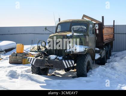 Un vieux camion à six roues motrices abandonné du milieu du XXe siècle dans la neige en hiver Banque D'Images