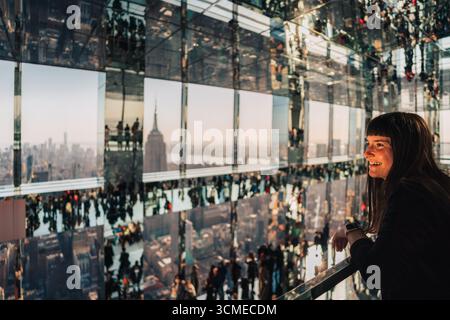 02.19.2022, New York, NY : femme jouit de la vue sur l'Empire State Building depuis la terrasse d'observation Summit One Vanderbilt. Banque D'Images