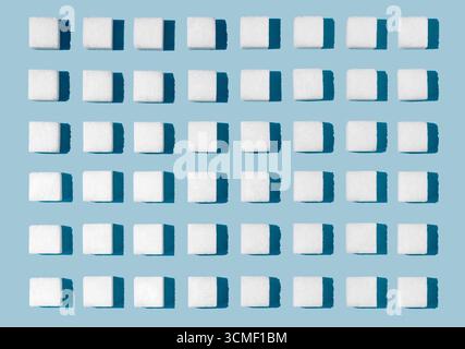 Cubes de sucre blanc disposés pour l'effet sur fond bleu Banque D'Images