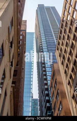 Regardant vers le haut les gratte-ciels imposants comme des géants pointant vers le ciel. Lignes de perspective fortes pointant vers le haut. Vieux et nouveaux bâtiments le long du côté Banque D'Images