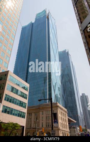Regardant vers le haut les gratte-ciels imposants comme des géants pointant vers le ciel. Lignes de perspective fortes pointant vers le haut. Reflets du soleil dans le verre Banque D'Images