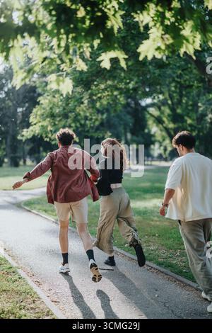 Amis profitant d'une promenade insouciante à travers un parc verdoyant ensemble Banque D'Images