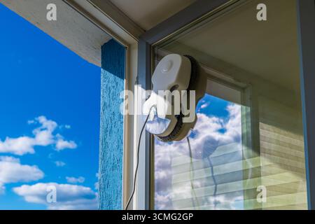 Robot lave-vitres lave le verre avec des chiffons ronds, service robotique, technologies modernes Banque D'Images