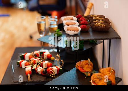 Un assortiment magnifiquement arrangé de desserts et hors-d'œuvre, avec muffins, chocolats et bouchées salées sur des plateaux étagés. idéal pour les célébrations Banque D'Images