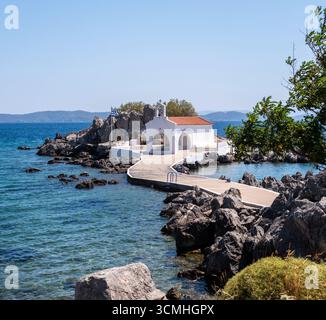 Chios, petite église d'Agios Isidoros, Grèce. Chapelle d'architecture traditionnelle avec toit de tuiles rouges et clocher sur les rochers, journée d'été ensoleillée Banque D'Images