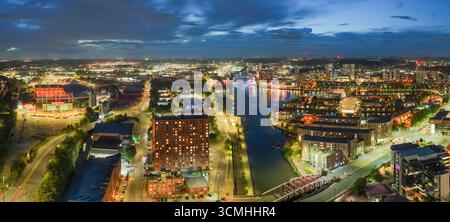 Vue aérienne panoramique au crépuscule des quais de Manchester et de Salford avec les lumières de la ville reflétant sur l'eau. Banque D'Images