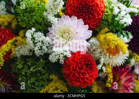 Ce bel arrangement présente des fleurs vibrantes en rose, rouge, jaune et blanc. Parfait pour les événements nuptiaux d'automne, il capture l'essence de l'automne Banque D'Images