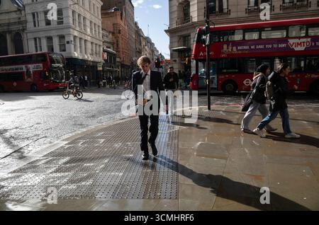 Les travailleurs de la ville de Londres bravent les rafales d'automne et les averses de pluie le long de Bishopsgate, dans le quartier financier de Londres, en Angleterre, au Royaume-Uni Banque D'Images