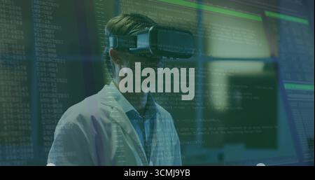 Chercheur debout portant un casque VR et une blouse de laboratoire dans un laboratoire de recherche, avec des superpositions de code sur les moniteurs Banque D'Images