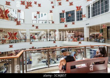Aventura Mall Miami Florida, à l'intérieur des magasins, installation d'art papillon plafond suspendu, vue atrium centre commercial à plusieurs niveaux, homme femme sitti Banque D'Images