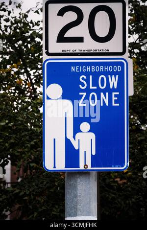 Un panneau pour une zone lente de quartier avec une limite de vitesse de 20 miles par heure aidant ainsi les enfants, à Sunnyside, Queens, New York. Banque D'Images