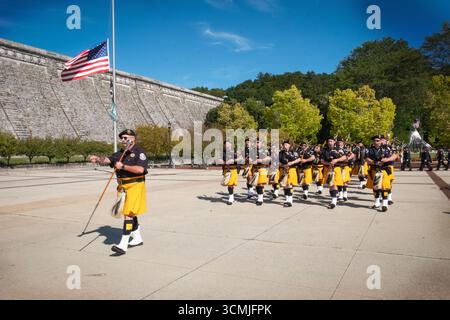 Les tuyaux et les tambours de la police Emerald Society of Westchester défilent avant le chant de l'hymne national lors de la cérémonie commémorative du 11 septembre. Banque D'Images