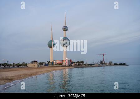 Les tours du Koweït se dressent le long du front de mer avec une plage de sable et les eaux calmes du golfe Persique à Koweït City, Koweït. Koweït City, Koweït. Banque D'Images