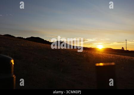 Cieux de coucher de soleil enflammé et crépuscule sur les collines de Contra Loma à Antioch, Californie. Le paysage d'East Bay est capturé dans des couleurs vives Banque D'Images