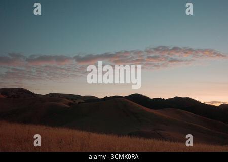 Cieux de coucher de soleil enflammé et crépuscule sur les collines de Contra Loma à Antioch, Californie. Le paysage d'East Bay est capturé dans des couleurs vives Banque D'Images