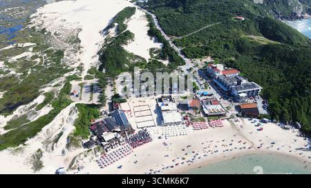 Vue aérienne panoramique de la plage de Joaquina à Florianopolis, Santa Catarina, bondé de gens et de parasols par une journée d'été ensoleillée avec bleu turquoise Banque D'Images