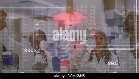 Chercheurs collaborant esquissant des diagrammes avec marqueur sur panneau de verre dans le laboratoire, avec stylo pour ordinateur portable Banque D'Images