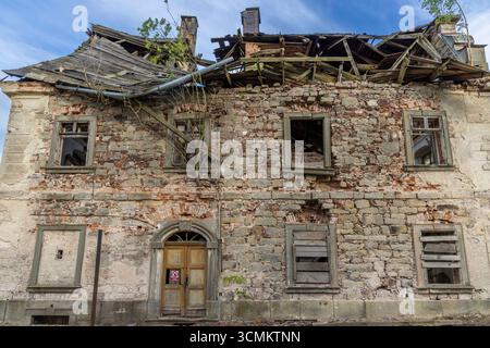 Façade en ruine d'un bâtiment abandonné montrant la pourriture et la négligence, situé à Sonov, Tchéquie Banque D'Images