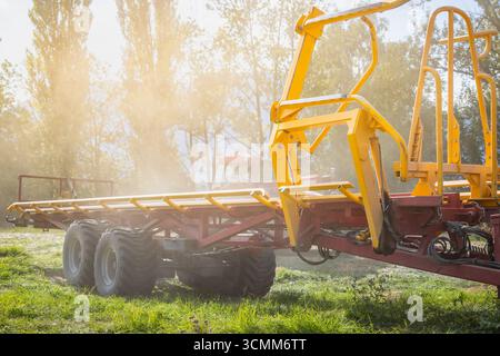 Vider la remorque du tracteur après avoir emporté des balles de foin empilées Banque D'Images