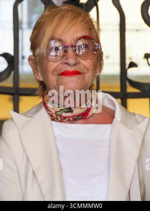 Cremona, Italie - 3 septembre 2025 femme élégante âgée avec rouge à lèvres et lunettes à la mode à l'extérieur à Cremona Italie été Banque D'Images