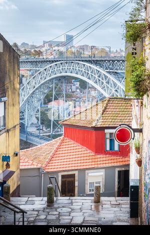 Vue sur le pont Dom Luis I depuis les rues du quartier historique de Porto. Architecture portugaise, toits de tuiles rouges, escaliers, paysage urbain, citysc au bord de la rivière Banque D'Images