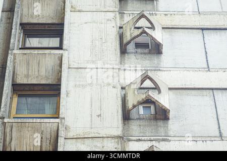 Façade en béton brut avec fenêtres angulaires brutalistes. Gros plan de la tour Genex à Belgrade. Détails architecturaux, patrimoine moderne et design urbain Banque D'Images