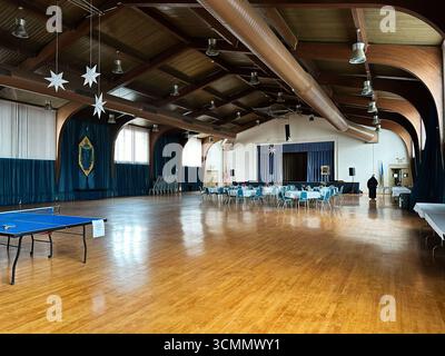 Newark, New Jersey, États-Unis - 1er avril 2025 : salle spacieuse avec parquet, rideaux bleus et organisation de repas événementiels. Banque D'Images
