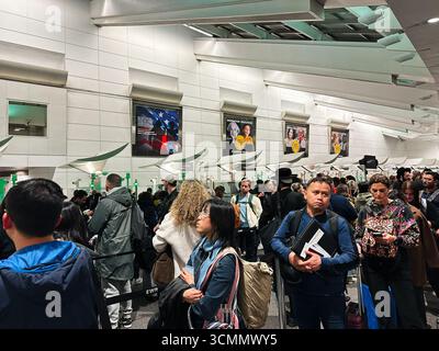 Newark, New Jersey, États-Unis - 01 avril 2025 : groupe diversifié de passagers faisant la queue dans une zone douanière de l'aéroport de Newark, New Jersey. Banque D'Images
