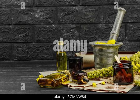 Concept de soin naturel avec fleurs Verbascum, ingrédient à base de plantes pour huiles, crèmes et soins de beauté. Fond en bois noir, espace de copie Banque D'Images