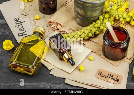 Concept de soin naturel avec fleurs Verbascum, ingrédient à base de plantes pour huiles, crèmes et soins de beauté. Fond en bois noir, gros plan Banque D'Images