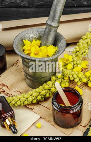 Concept de soin naturel avec fleurs Verbascum, ingrédient à base de plantes pour huiles, crèmes et soins de beauté. Fond en bois noir, gros plan Banque D'Images