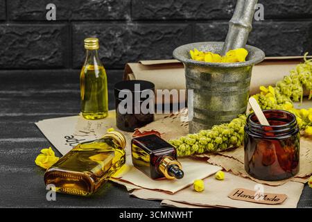 Concept de soin naturel avec fleurs Verbascum, ingrédient à base de plantes pour huiles, crèmes et soins de beauté. Fond en bois noir, espace de copie Banque D'Images