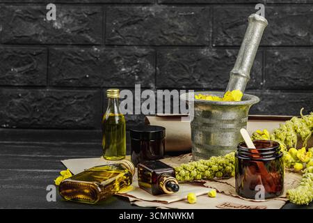 Concept de soin naturel avec fleurs Verbascum, ingrédient à base de plantes pour huiles, crèmes et soins de beauté. Fond en bois noir, espace de copie Banque D'Images