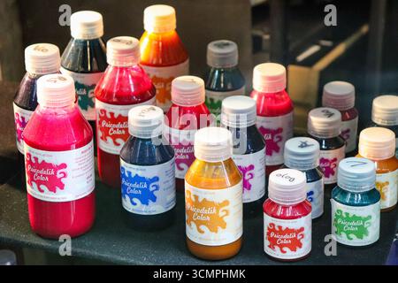Pots d'encre de tatouage avec bouchons à vis, de différentes tailles et couleurs vibrantes, disposés sur une table dans un studio de tatouage à l'intérieur de Galeria Bond Street. Buenos A Banque D'Images