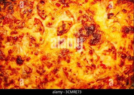 Fond de pizza avec beaucoup de fromage gros plan, vue de dessus. Banque D'Images