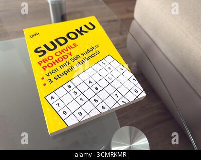 Ostrava, Tchéquie - 23 décembre 2024 : Livre avec mots croisés Sudoku et puzzle sur table en verre Banque D'Images