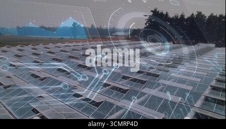 Panneaux solaires en rangées étendus sur des montages en rack au-dessus d'un sol rural herbeux, affichant des superpositions de données Banque D'Images