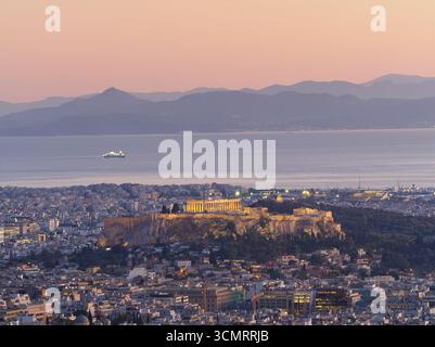 Vue aérienne d'Athènes avec Acropole illuminé et Parthénon au coucher du soleil surplombant la mer Banque D'Images