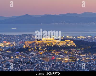 Acropole illuminé et Parthénon surplombant le paysage urbain d'Athènes au crépuscule avec les montagnes au-delà Banque D'Images