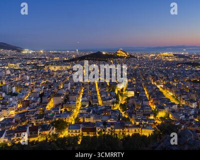 Vue panoramique d'Athènes, Grèce au crépuscule montrant les rues illuminées et la colline de l'Acropole Banque D'Images
