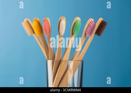 Ensemble de brosses à dents en bambou coloré en verre sur fond bleu, gros plan. Zéro déchet, sans plastique, concept de produit organique respectueux de l'environnement Banque D'Images