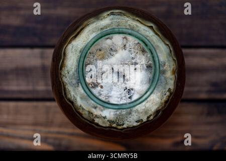 Moisissure dangereuse dans un bocal en verre avec une boisson sucrée, gros plan, vue de dessus. La moisissure est très dangereuse pour la santé. Particules de virus, champignons dans la boisson, vieux moisissure i. Banque D'Images