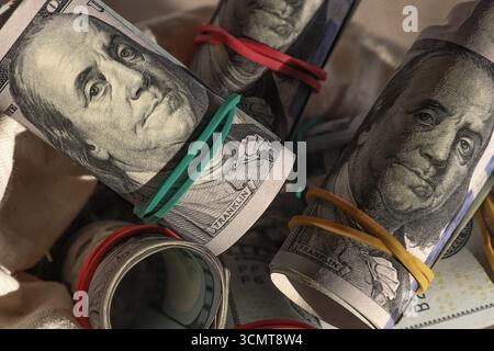 Billets de banque en dollars US roulés attachés avec des élastiques gros plan, symbole d'épargne, d'investissement, de richesse, de profit et de sécurité financière. Banque D'Images