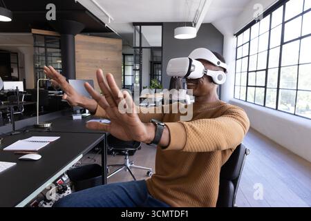 Clavier sans fil, souris et moniteur reposant sur le bureau dans un bureau moderne près de grandes fenêtres Banque D'Images