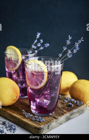 Limonade d'été avec lavande, jus de citron et bleuets dans deux verres sur fond sombre Banque D'Images