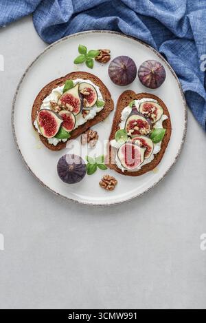 Sandwichs aux figues, fromage à la crème, basilic et miel sur fond clair, vue de dessus Banque D'Images