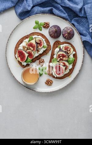 Sandwichs aux figues, fromage à la crème, basilic et miel sur fond clair, vue de dessus Banque D'Images