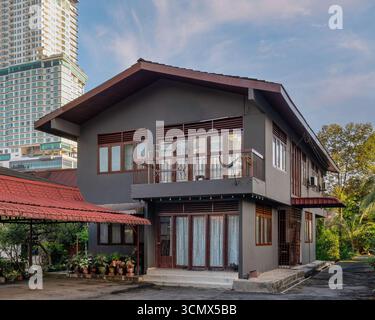 Maison résidentielle à Kampong Bharu, Kuala Lumpur, Malaisie, avec un immeuble moderne de grande hauteur en arrière-plan. Développement urbain et contraste architectural Banque D'Images